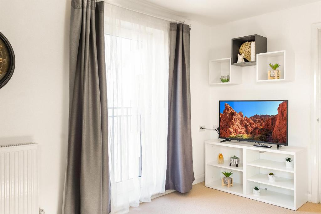 a living room with a tv and a window at Leap Onyx Apartment - Northampton Town Centre in Northampton