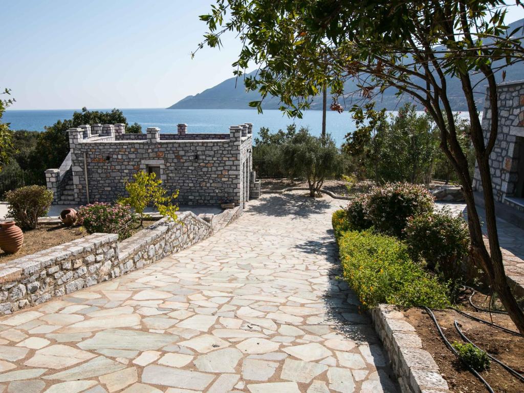 una pasarela de piedra frente a un edificio con un árbol en Skourari Bungalows Galini room en Skoutárion