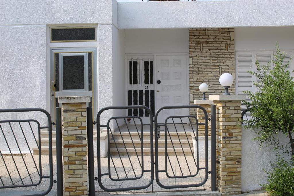 un portail en face d'une maison blanche dans l'établissement Costas Hostel Action 2, à Nicosie