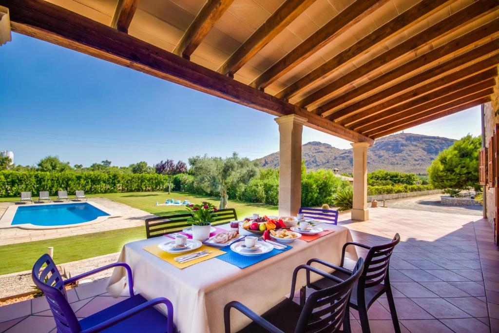 a dining table on a patio with a view of a pool at Ideal Property Mallorca - Ses Poves in Alcudia