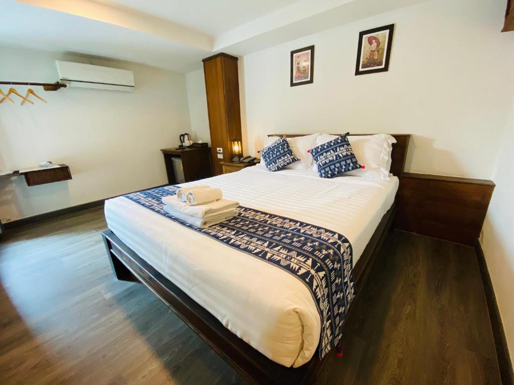 a bedroom with a large bed with blue pillows at C Hotel Boutique and Comfort in Chiang Mai