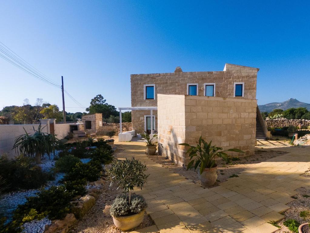 una casa in mattoni con piante di fronte di Cava Rossa a Favignana