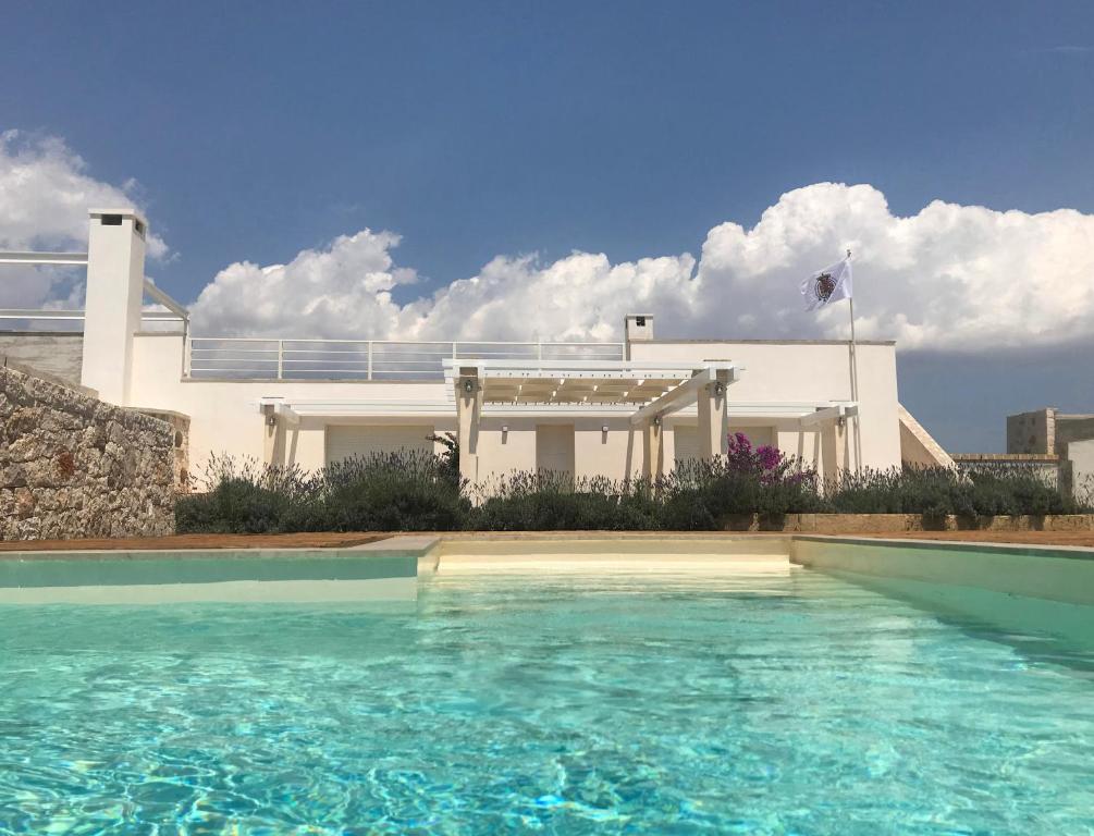 une maison avec une piscine devant une maison dans l'établissement Villa Pietraja, à Ugento
