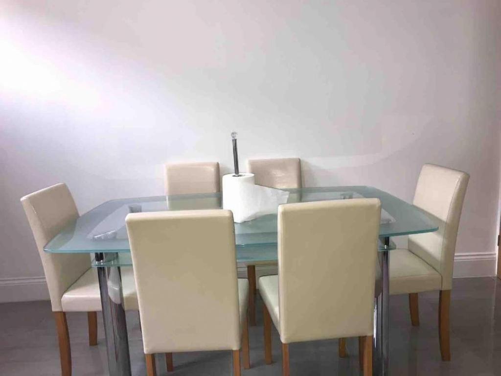a dining room table and chairs with a blue table and a candle at Entire Whalley House in Burnley