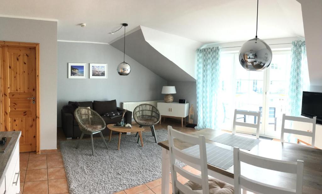 een eetkamer en een woonkamer met een tafel en stoelen bij Ferienwohnung Möwe in Glowe