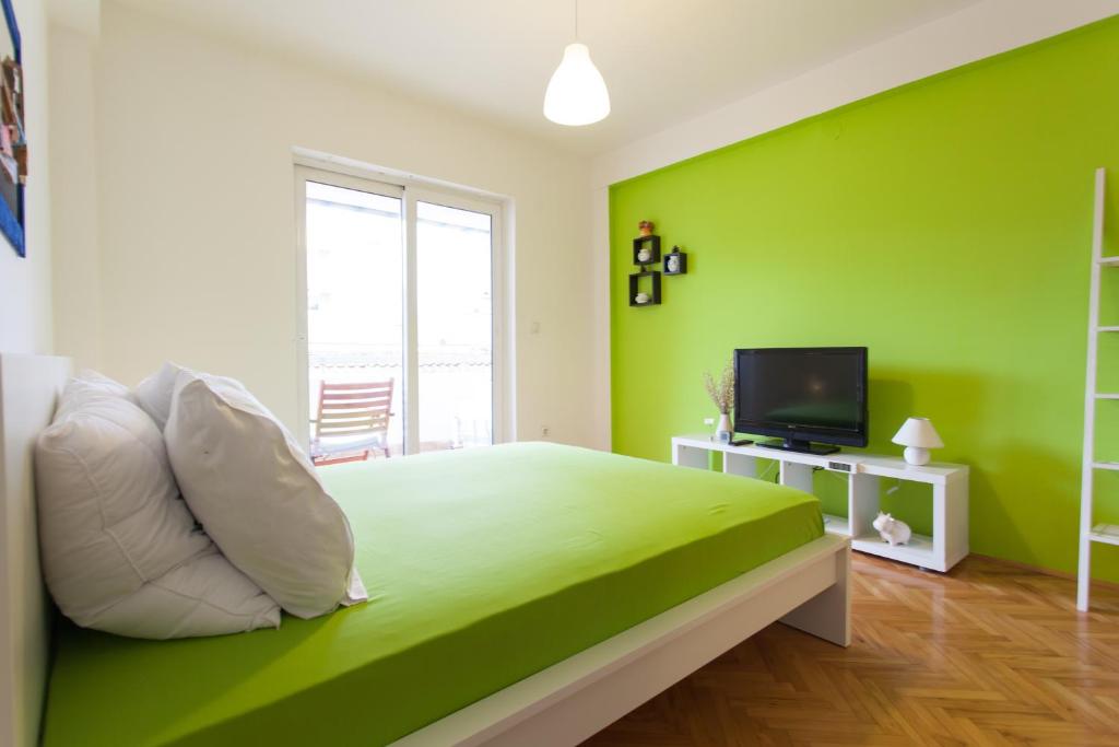 a green bedroom with a bed and a television at Apartment Partizanska in Ohrid