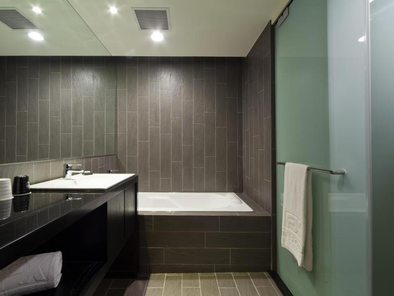 a bathroom with a bath tub and a sink at FX Hotel Taipei Nanjing East Road Branch in Taipei