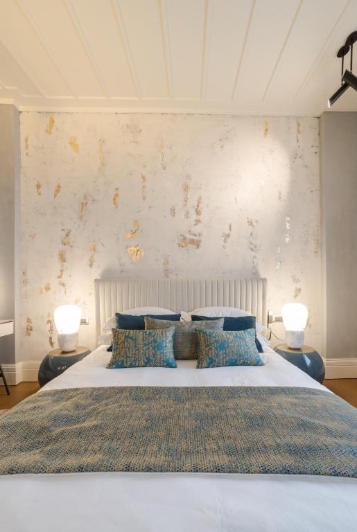 a bedroom with a large white bed with two lamps at Castellano Hotel & Suites in Nafplio
