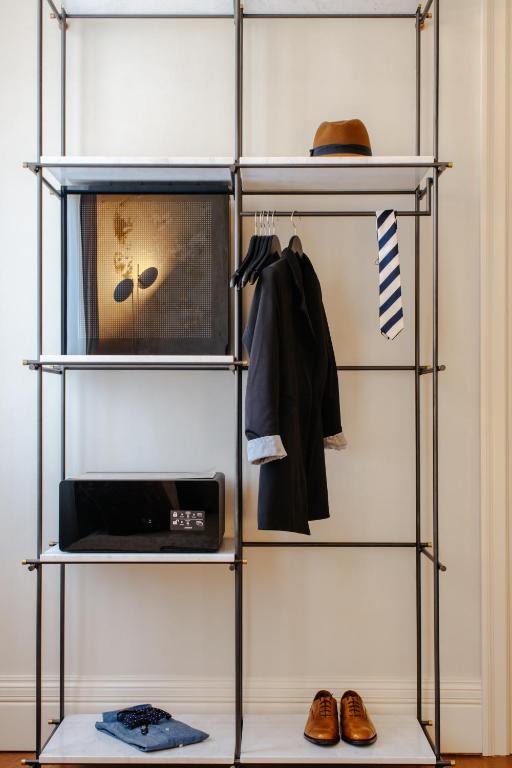 a metal shelving unit with a microwave and other items at Castellano Hotel & Suites in Nafplio