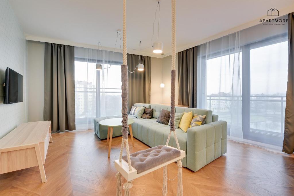 a living room with a couch and a swing at City Center - Granary Island by Apartmore in Gdańsk