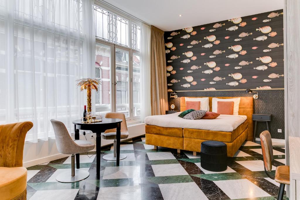 una camera con letto, tavolo e finestra di Brasss Hotel Suites a Haarlem