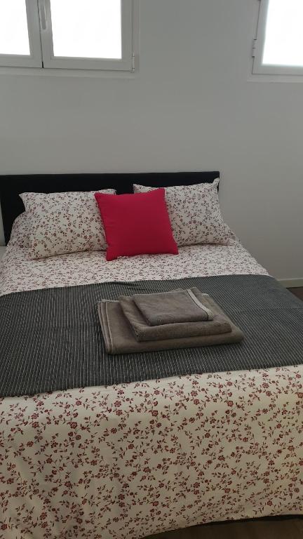 a bed with a tray on it with a red pillow at BELLADURMIENTE in Madrid