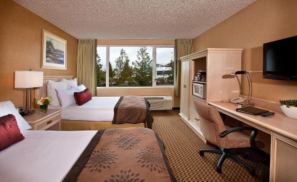 a hotel room with two beds and a desk at Coast Gateway Hotel in SeaTac