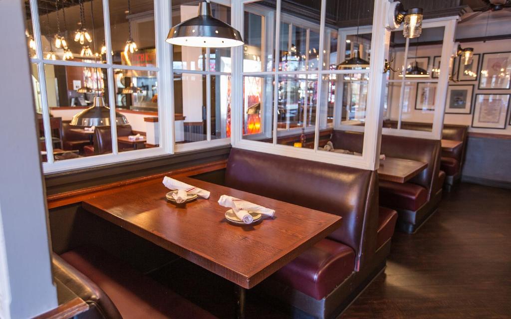 a restaurant with a wooden table and leather chairs at Coast Gateway Hotel in SeaTac