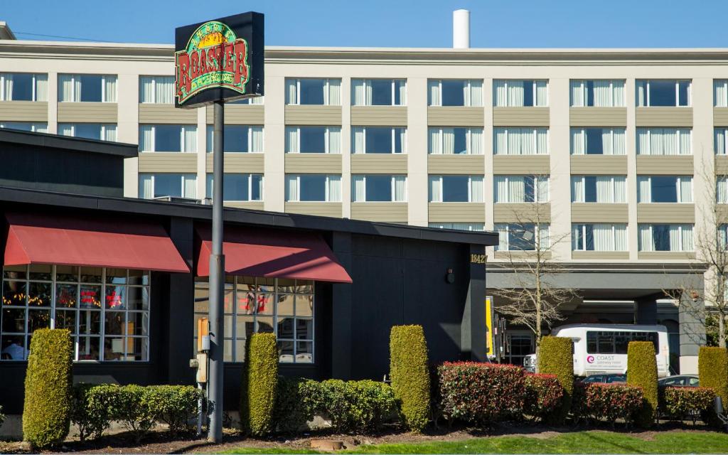 a hotel with a sign in front of a building at Coast Gateway Hotel in SeaTac