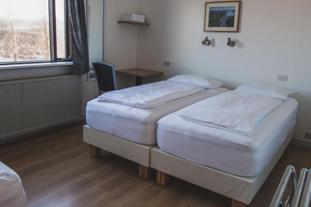 Rúm í herbergi á Ormurinn Guesthouse