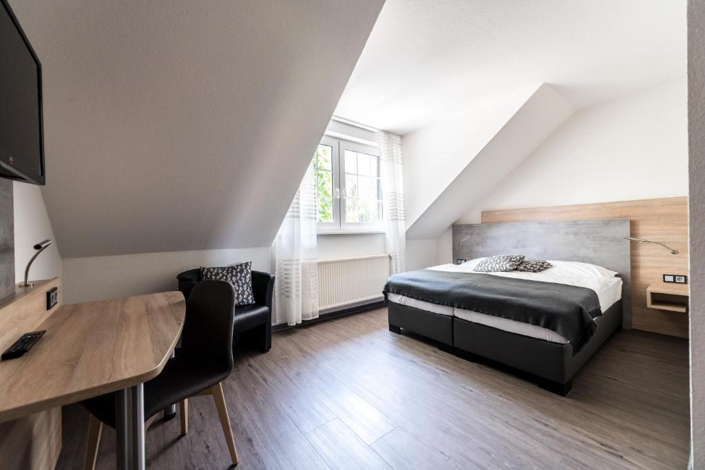 a bedroom with a bed and a desk and a table at Hotel Hüerländer in Münster