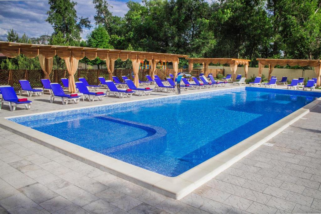 a swimming pool with blue chairs and a group at RELAX Hotel - restaurant Complex in Novomoskovsʼk