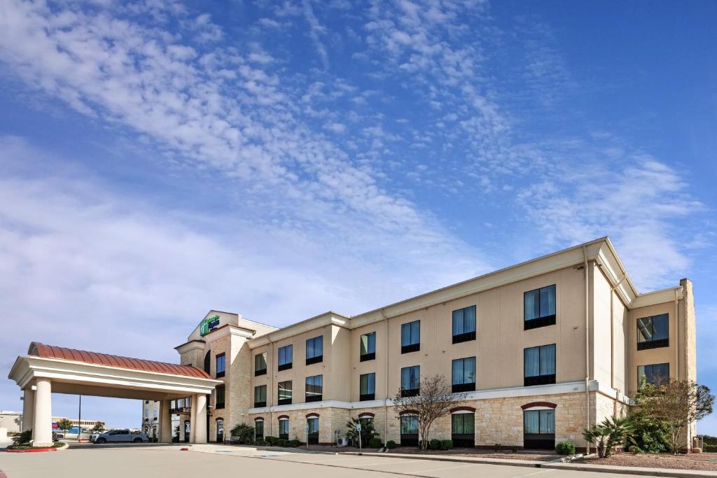 un edificio de hospital con un cielo azul en el fondo en Holiday Inn Express Hotel & Suites Floresville, an IHG Hotel, en Floresville