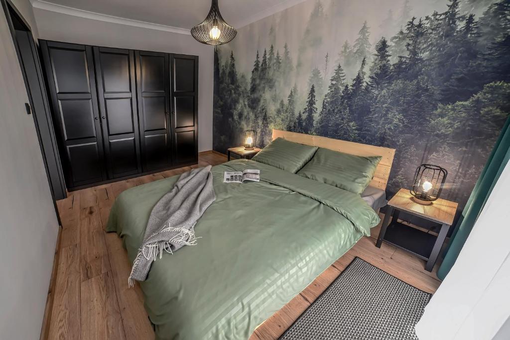 Un dormitorio con una cama verde con una pintura en la pared en Portowa Art, en Nowa Sól