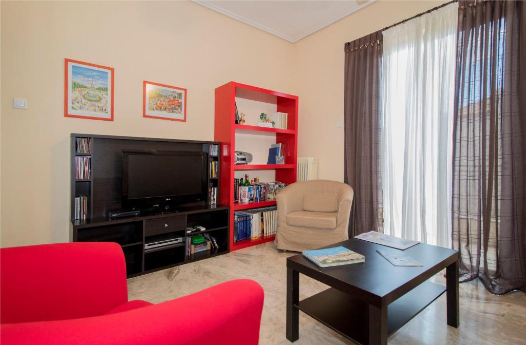 a living room with a red chair and a television at Laconian Collection Amalias in Sparta