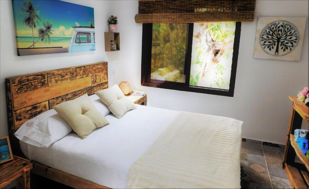 Un dormitorio con una cama blanca y dos ventanas. en Bungalow Marbella (San Pedro Alcantara), en Marbella