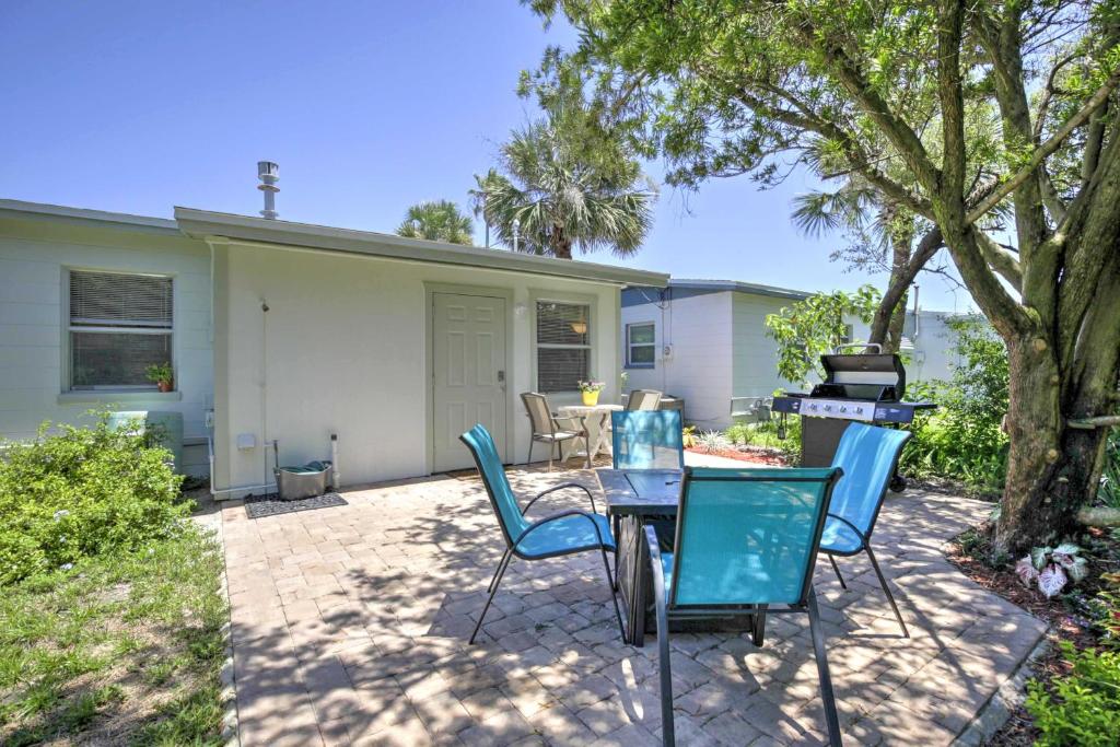 a patio with a table and chairs and a grill at Cozy NSB Abode with BBQ and Fire Pit - Walk to Beach! in New Smyrna Beach