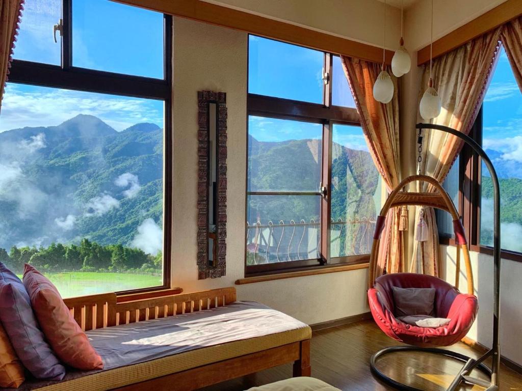 a bedroom with a large window with a view of a mountain at Margaret Garden Villa in Ren&#39;ai