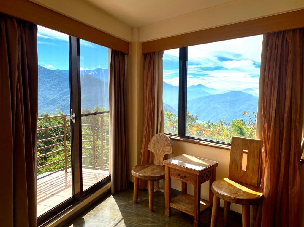 a room with a table and chairs and large windows at Margaret Garden Villa in Ren&#39;ai