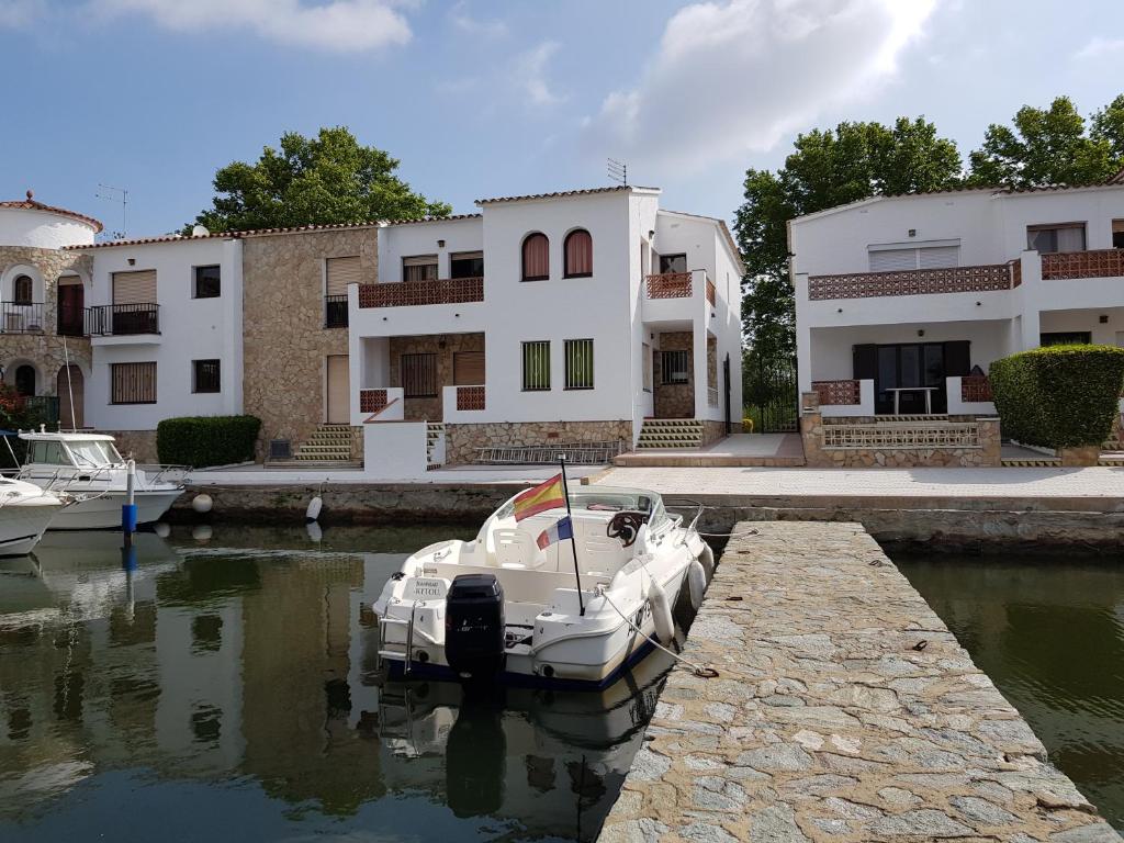 a white boat docked in the water in front of buildings at PORT LA SARDANA EmpuriaRent in Empuriabrava
