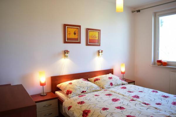 Un dormitorio con una cama con dos luces. en Apartament 2 sypialnie i balkon 500 m od morza en Ustka