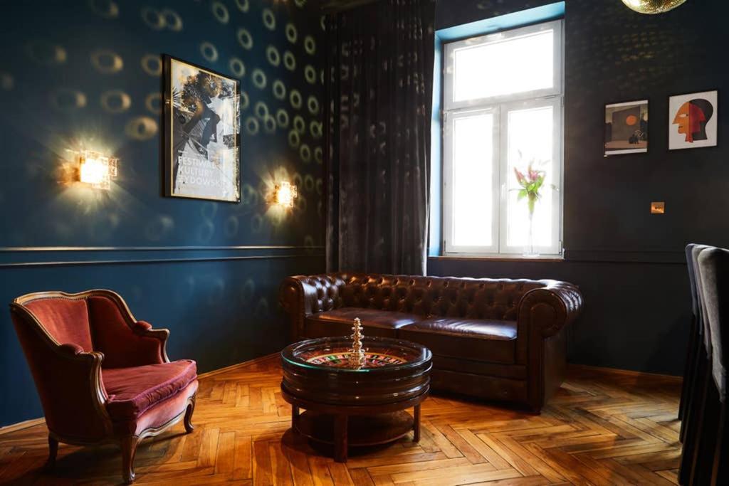 uma sala de estar com um sofá de couro e uma mesa em HOUSEHOST Apartment III: Podbrzezie Street em Cracóvia