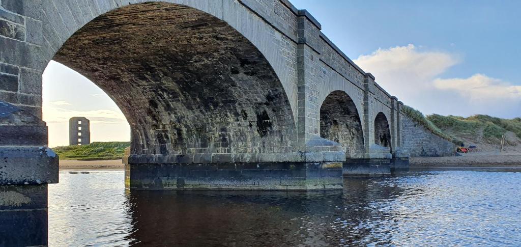 a stone bridge with two arches over the water at Bay View House in Liscannor