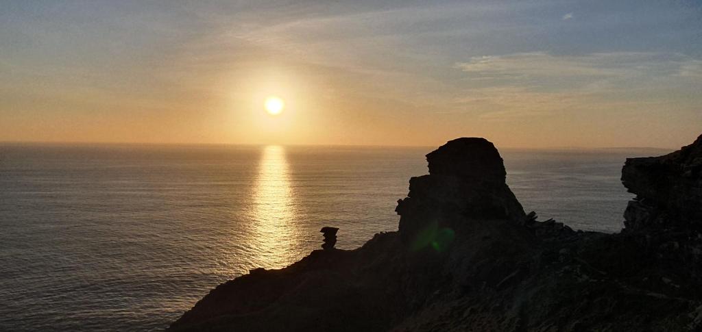 a person standing on top of a mountain overlooking the ocean at Bay View House in Liscannor