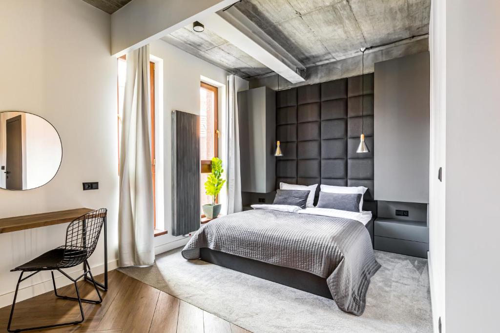 ein Schlafzimmer mit einem großen Bett und einem Stuhl in der Unterkunft Homewell Boutique Apartments Stare Miasto in Posen