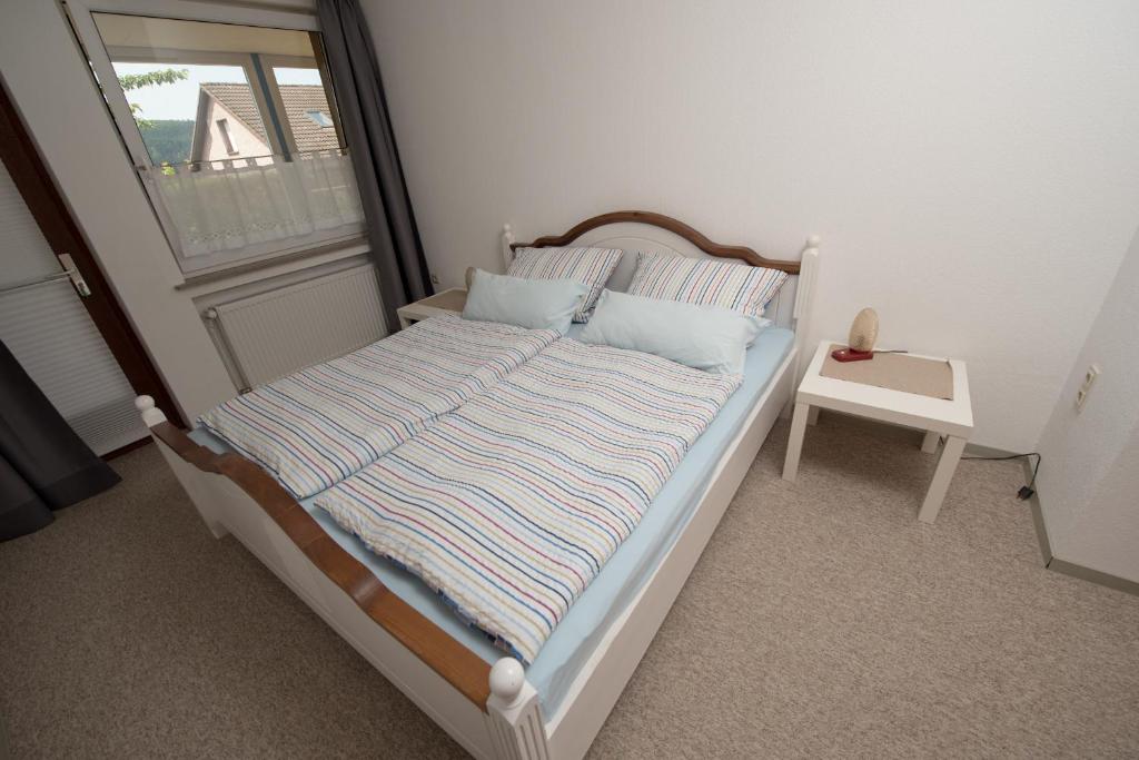 Bett in einem Zimmer mit Fenster in der Unterkunft FeWo Baron von Münchhausen in Bodenwerder