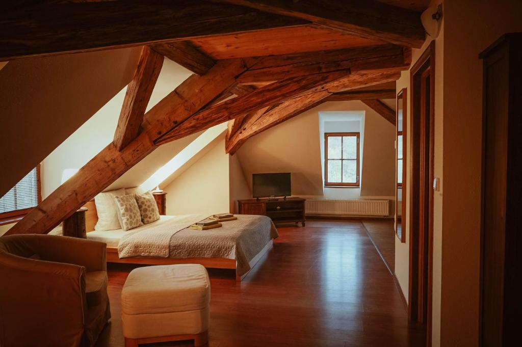 a attic bedroom with a bed and a tv at Hotel Stein Elbogen in Loket