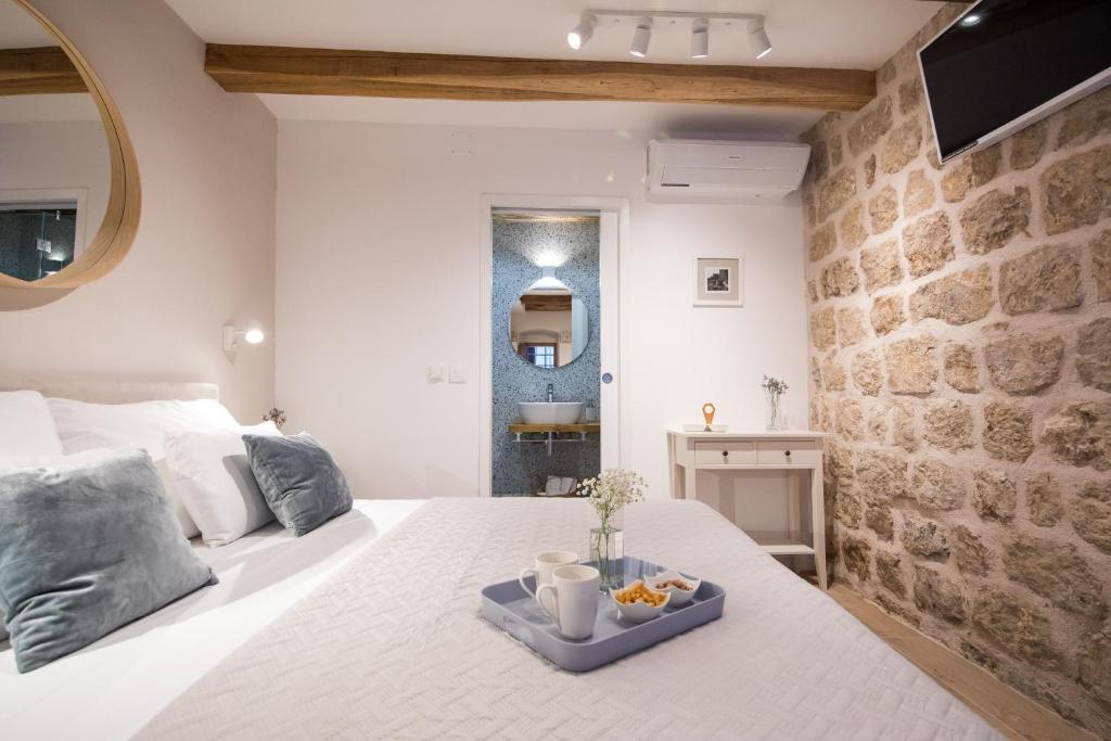 a bedroom with a white bed with a tray of fruit on it at Live Laugh Love Dubrovnik Luxury Rooms in Dubrovnik