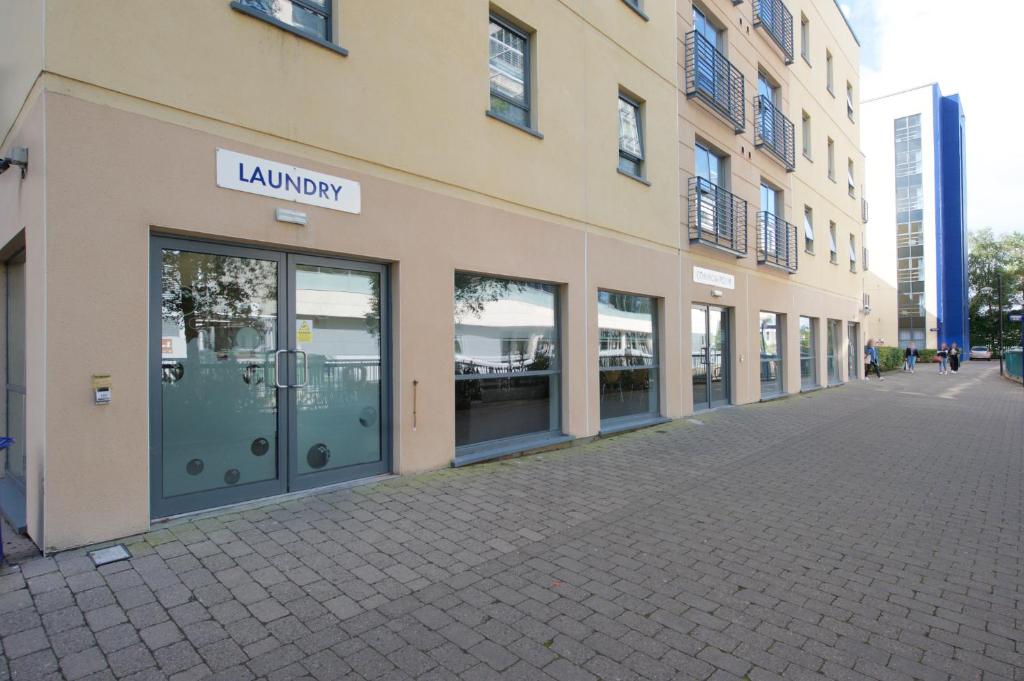 un edificio con una gran puerta de cristal en una calle en Victoria Lodge Apartments - UCC Summer Beds, en Cork