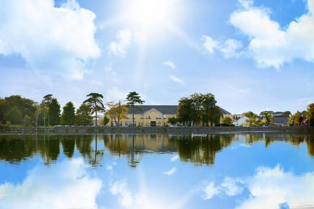 una casa reflejada en el agua de un lago en The Park Hotel Dungarvan, en Dungarvan