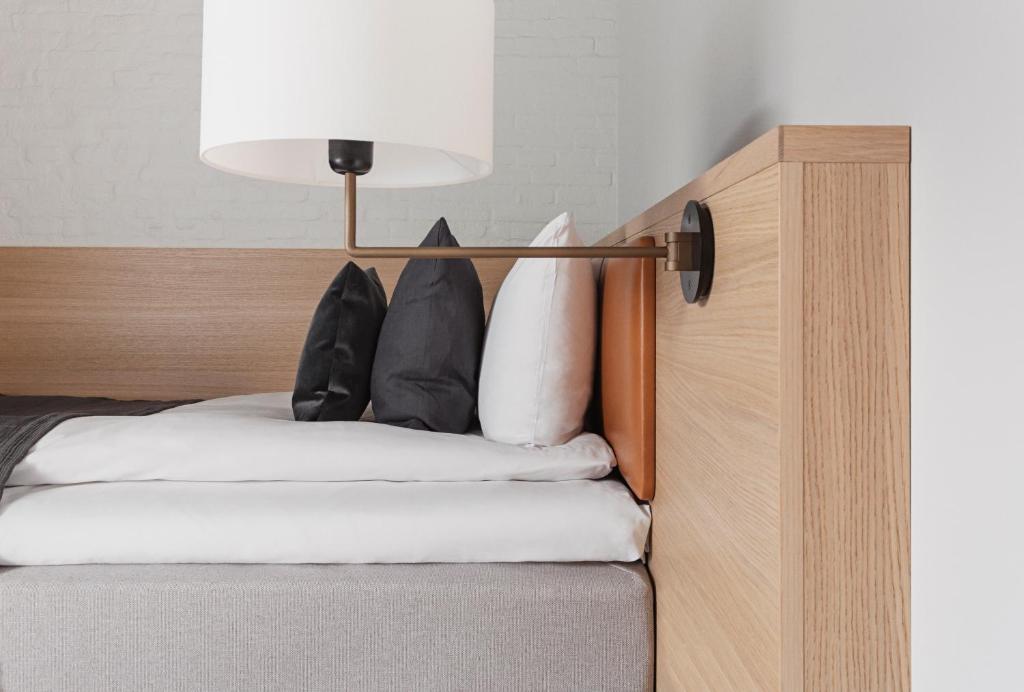 a bed with black and white pillows on it at Copenhagen Admiral Hotel in Copenhagen
