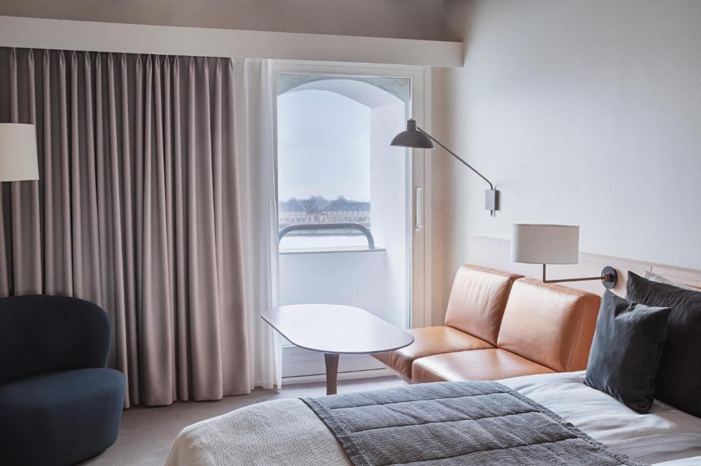 a living room with a couch and a table and a window at Copenhagen Admiral Hotel in Copenhagen