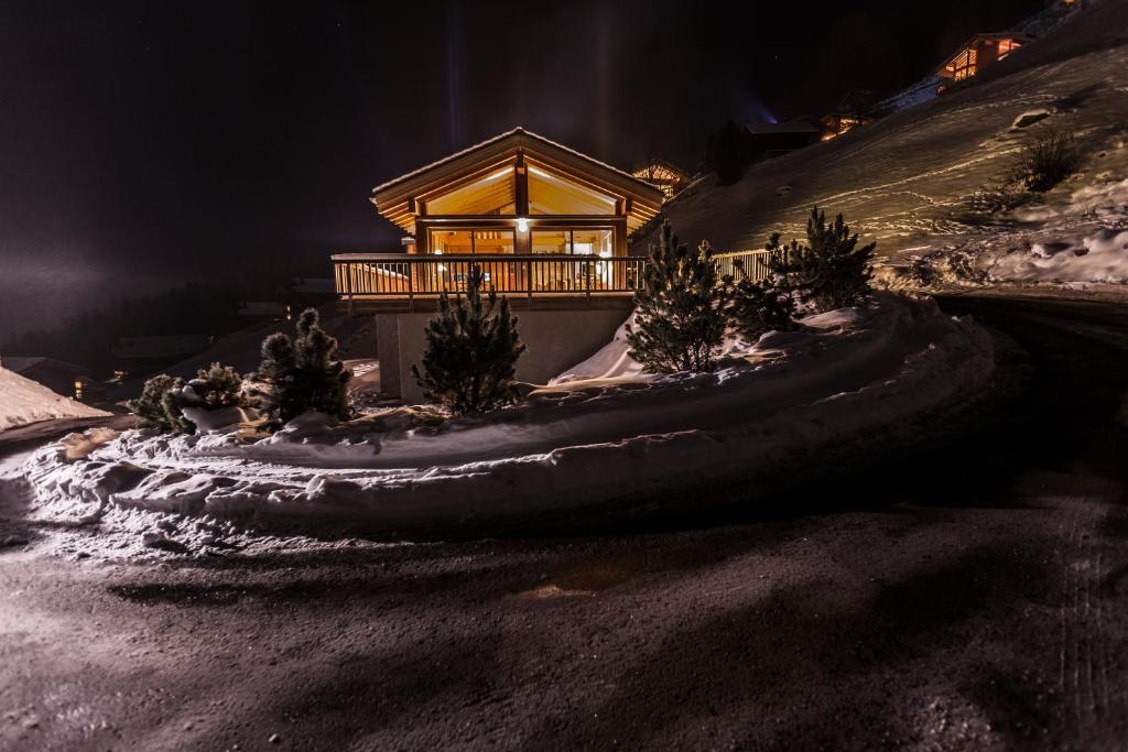 ein Haus an der Seite eines schneebedeckten Hügels in der Unterkunft Chalet Magrappe by Swiss Alps Village in Veysonnaz