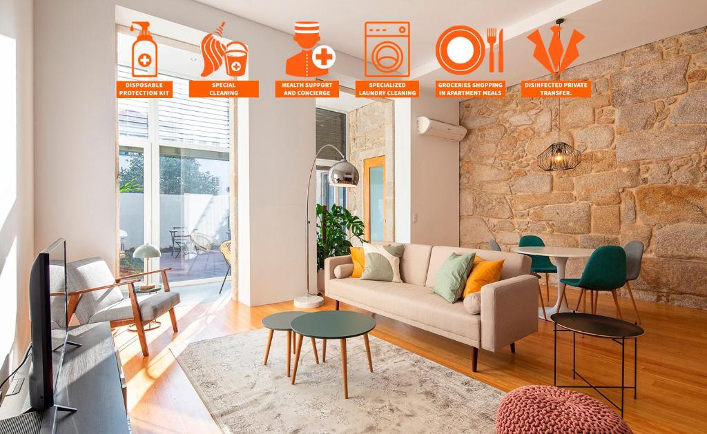a living room with a couch and a stone wall at Trindade Premium Suites & Apartments in Porto