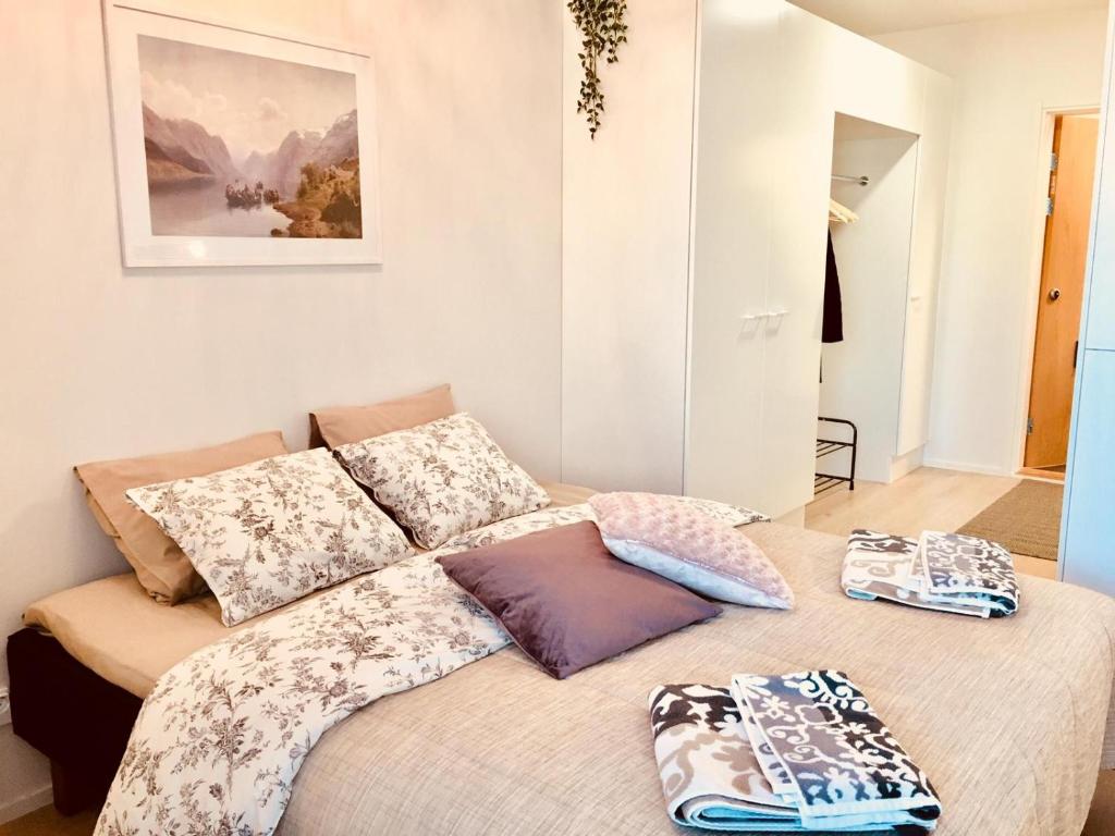 una cama con almohadas en una habitación en Patria apartments, en Lahti