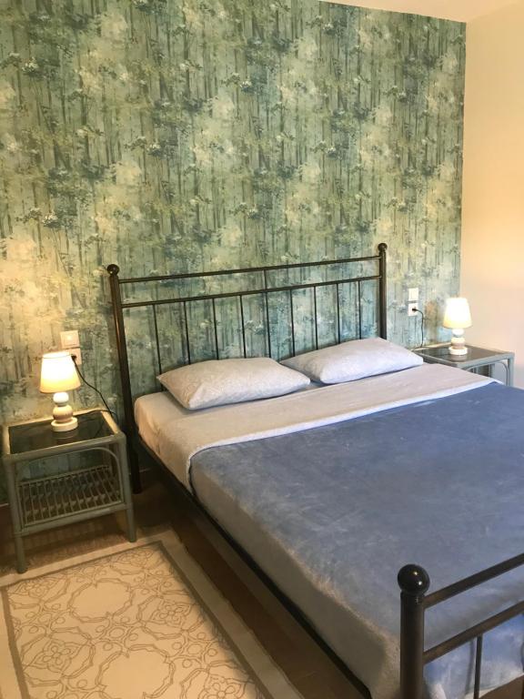 普拉塔利亞的住宿－Armonia Apartment，一间卧室配有一张床和两张带台灯的桌子。