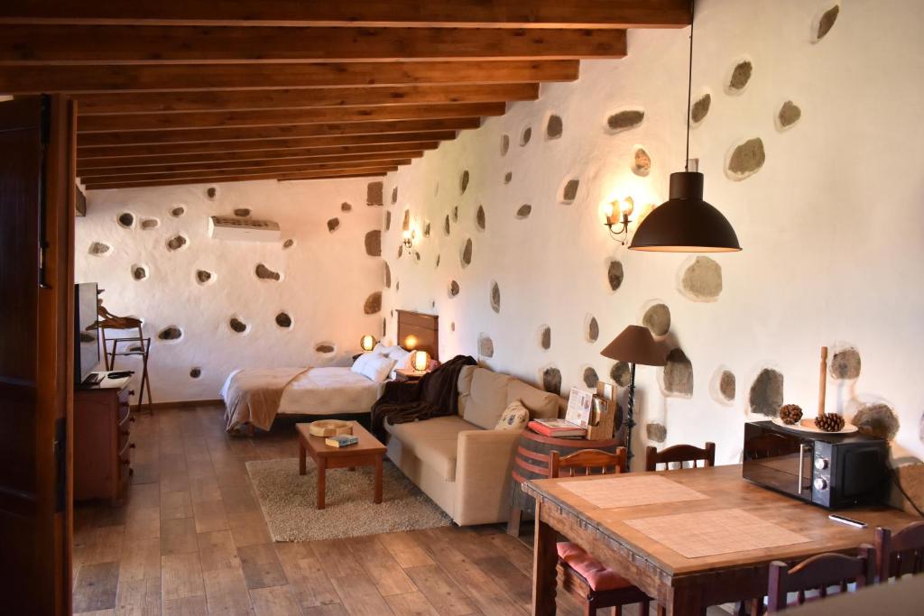 a living room with a stone wall at Finca Mariola - Alpendre in San Bartolomé de Tirajana