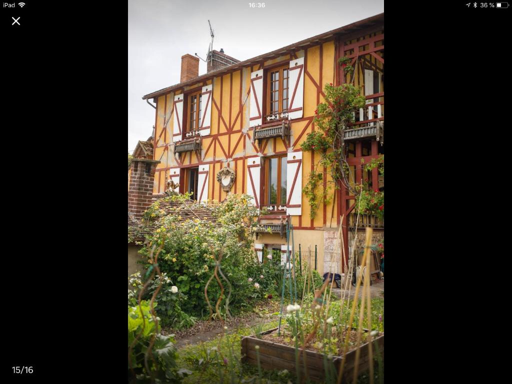 ein altes Gebäude mit Garten davor in der Unterkunft Les Papouz in Gommécourt