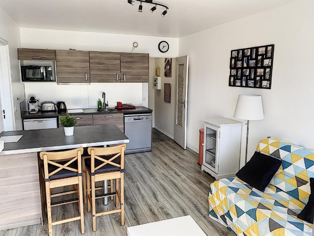 a kitchen and a living room with a couch at 2 PIECES CENTRE ET MER in Cabourg