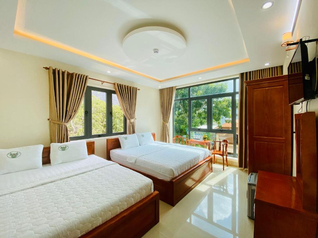 1 dormitorio con 2 camas y ventana grande en Khách sạn Phúc Lộc An Côn Đảo, en Con Dao